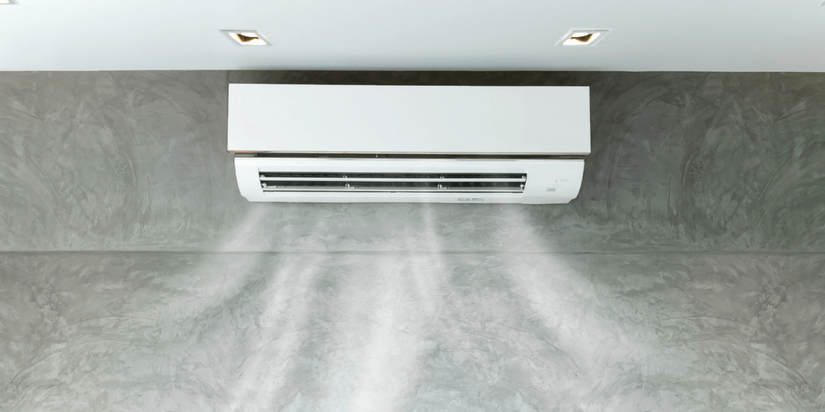 A white air conditioner heat pump releasing water mist into the air, providing cooling relief on a hot day